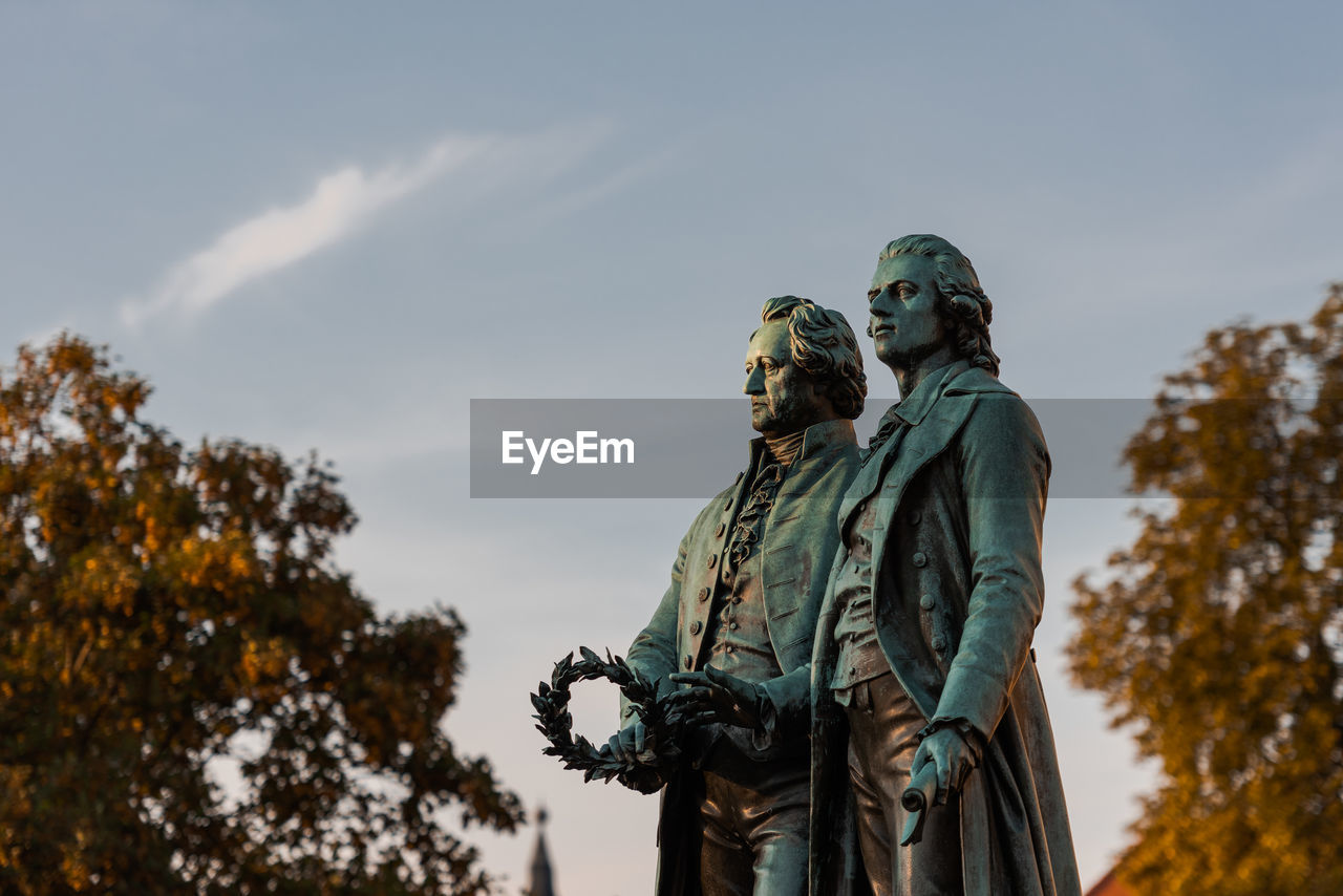 Low angle view of statues against sky