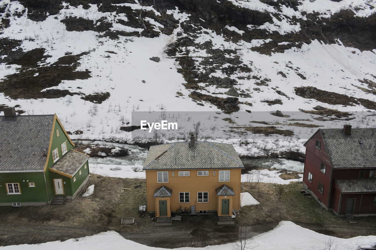 High angle view of snow covered houses by buildings