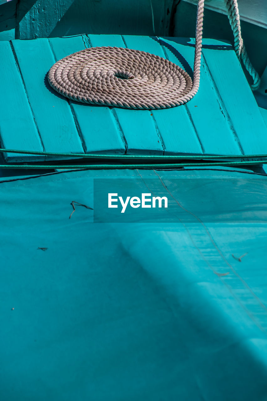 Ropes on blue boat during sunny day