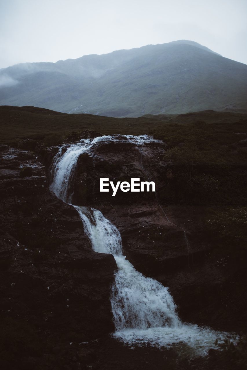 Scenic view of waterfall against sky