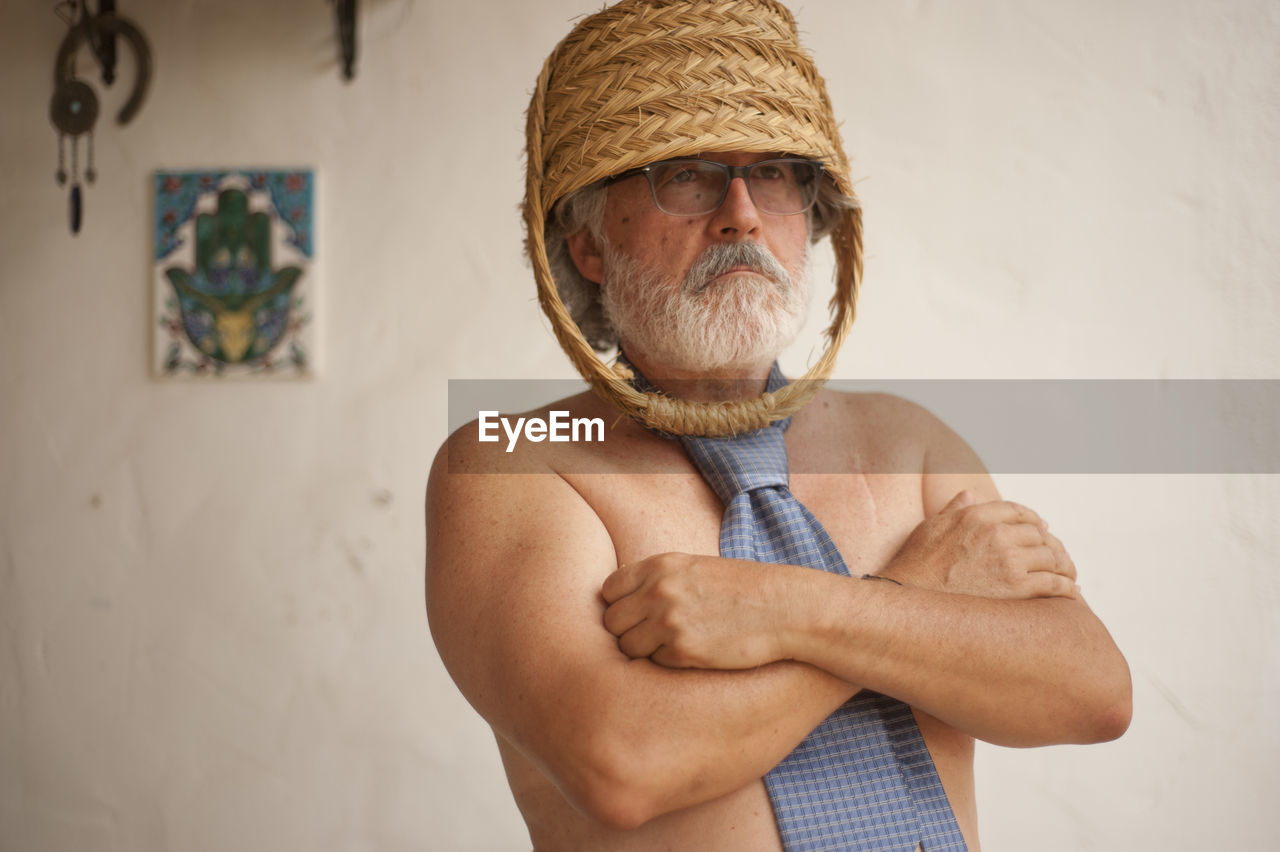 PORTRAIT OF MAN STANDING AGAINST WALL