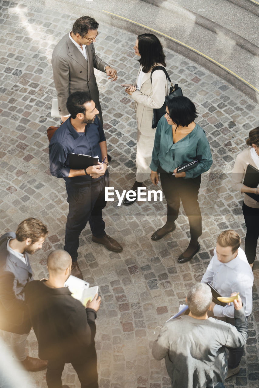 High angle view of male and female business people standing outdoors