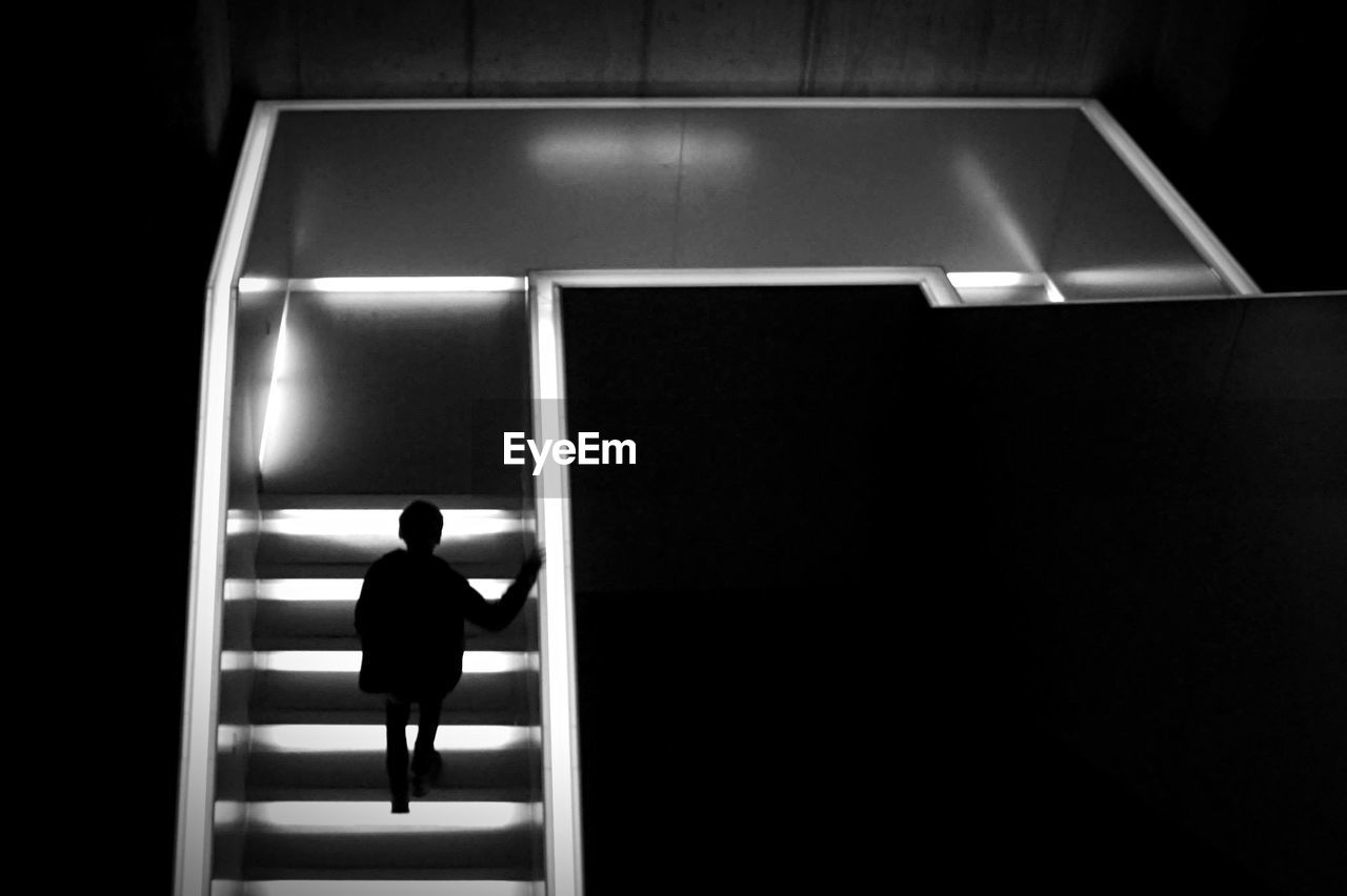 High angle view of person on illuminated staircase