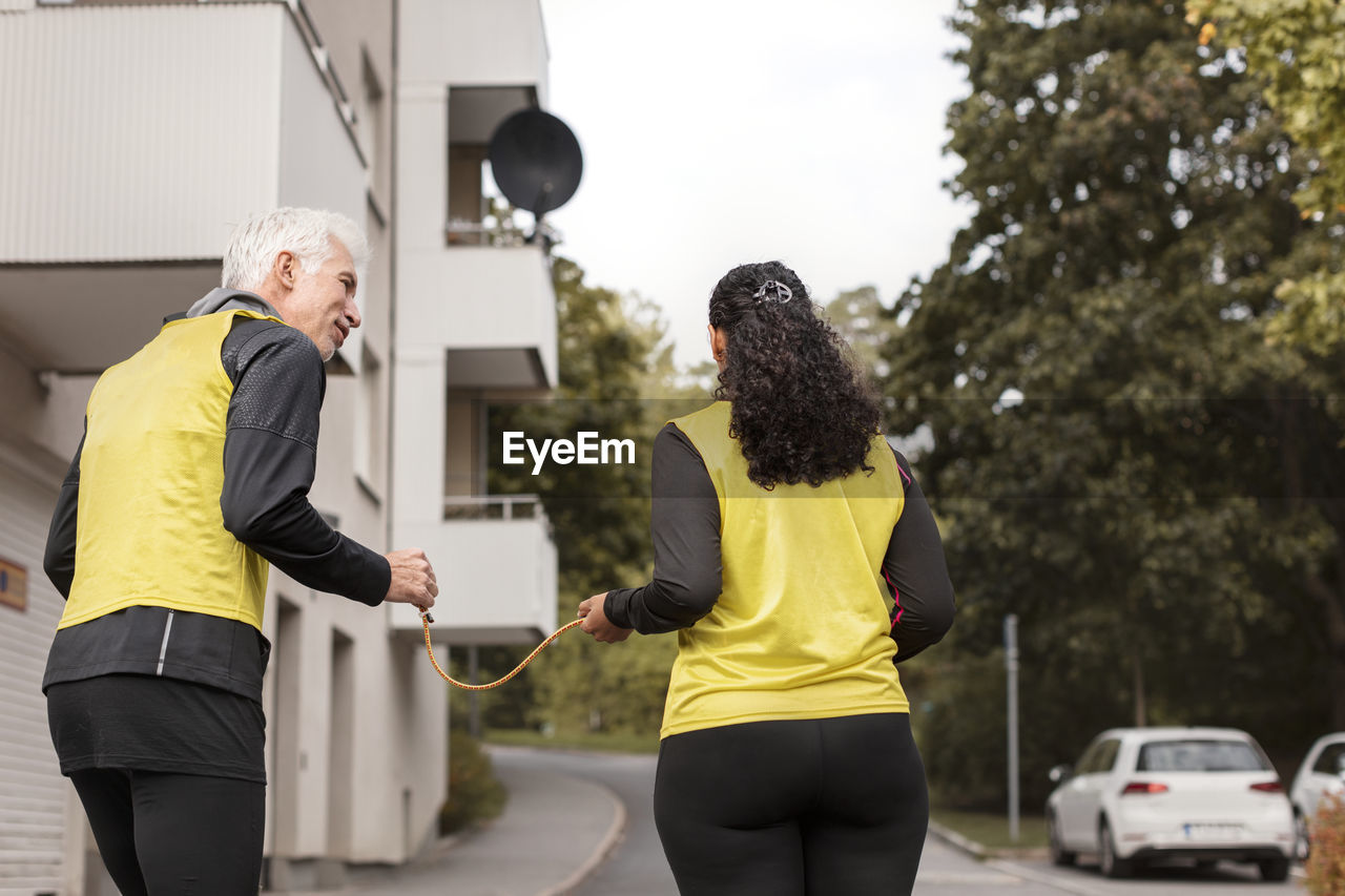 Visually impaired woman jogging with guide runner