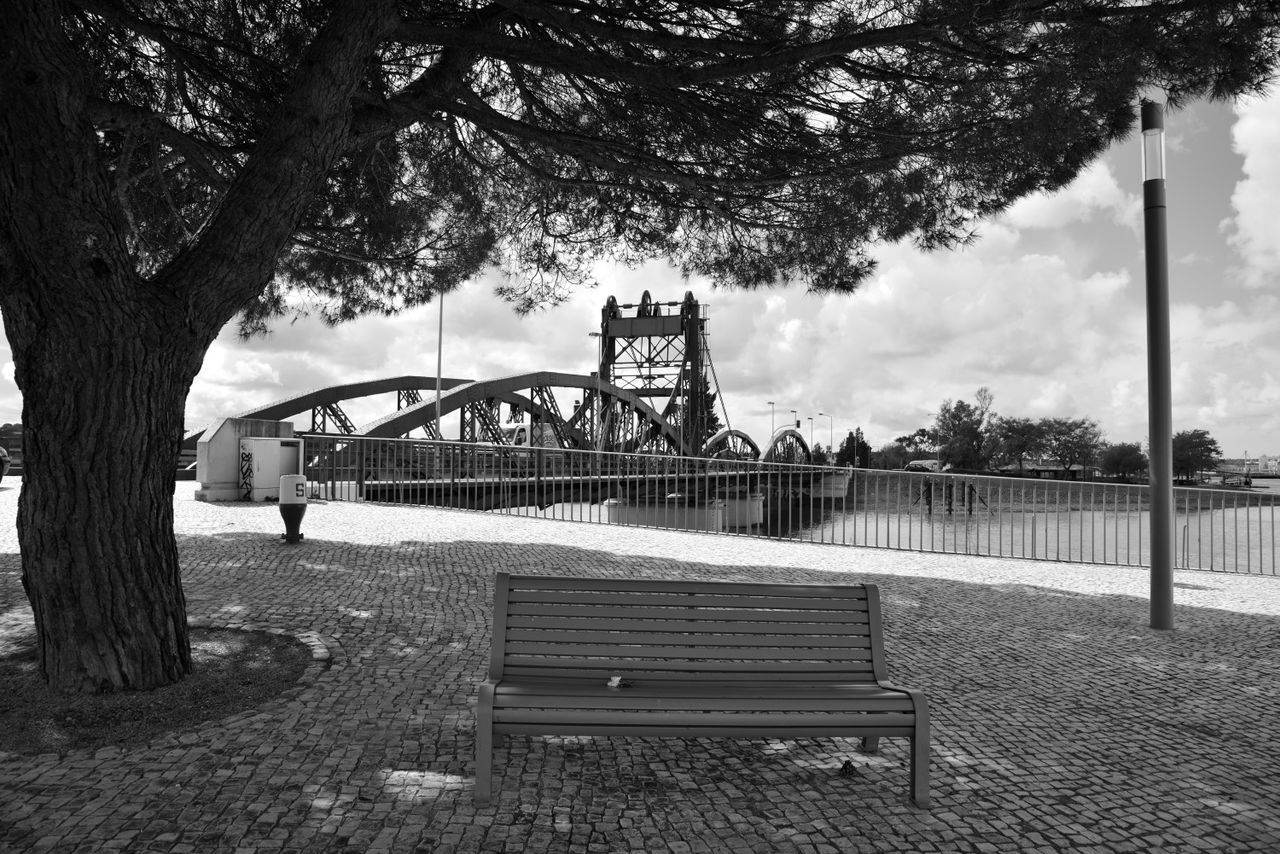 VIEW OF BRIDGE IN PARK AGAINST CLOUDY SKY