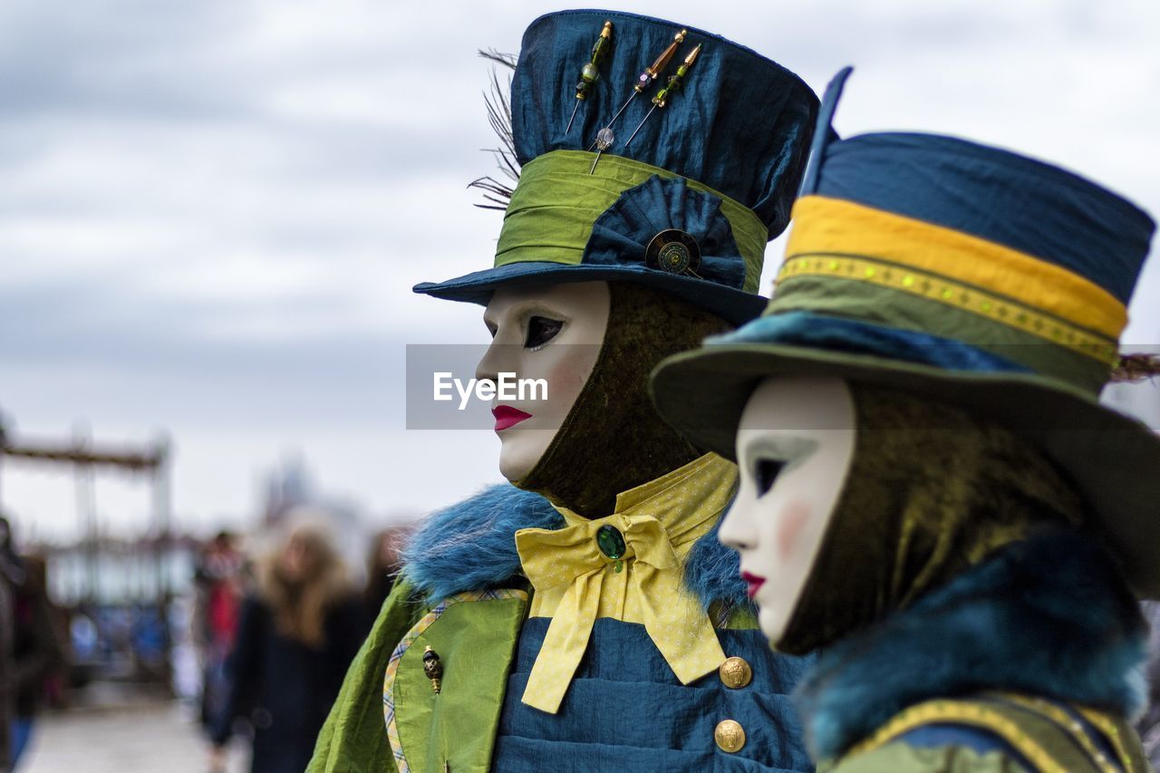 Close-up of people wearing mask and costume against sky