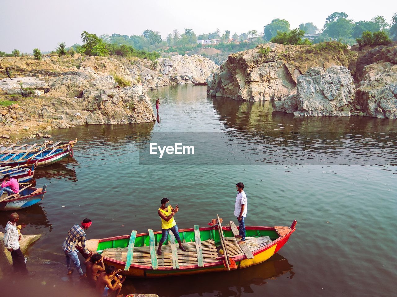 PEOPLE SITTING ON ROCKS AT SHORE