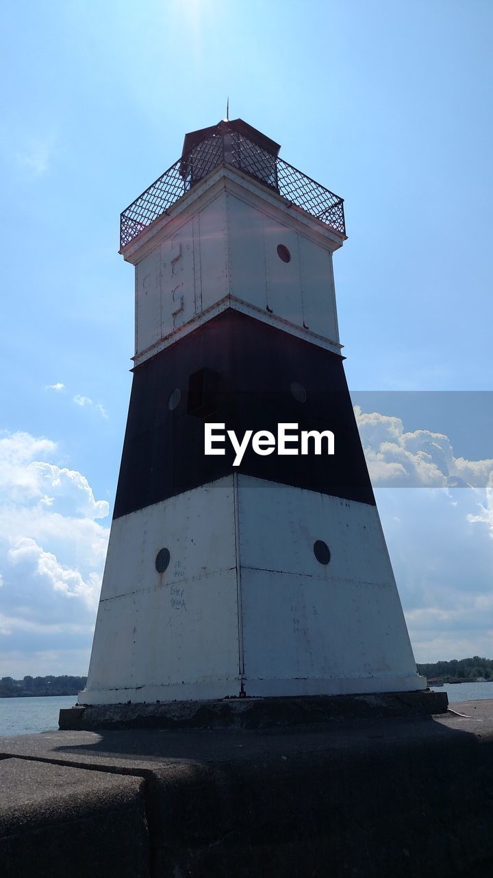 LOW ANGLE VIEW OF LIGHTHOUSE BY SEA AGAINST SKY