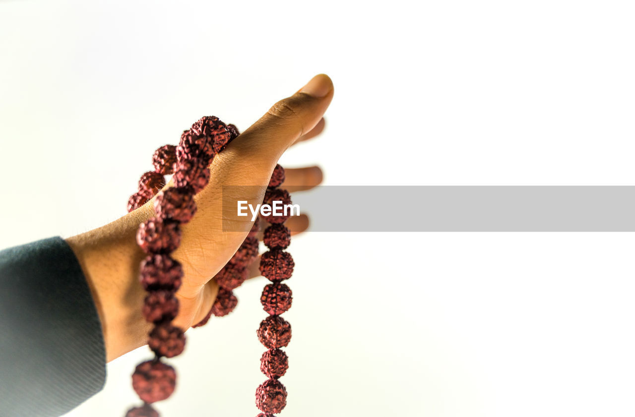 CLOSE-UP OF WOMAN HAND HOLDING COLORED BACKGROUND