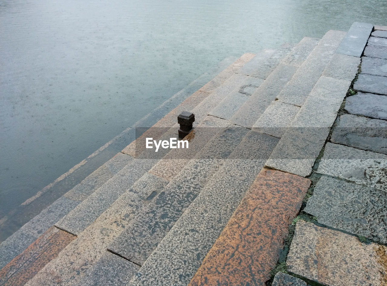 High angle view of wet steps leading towards lake