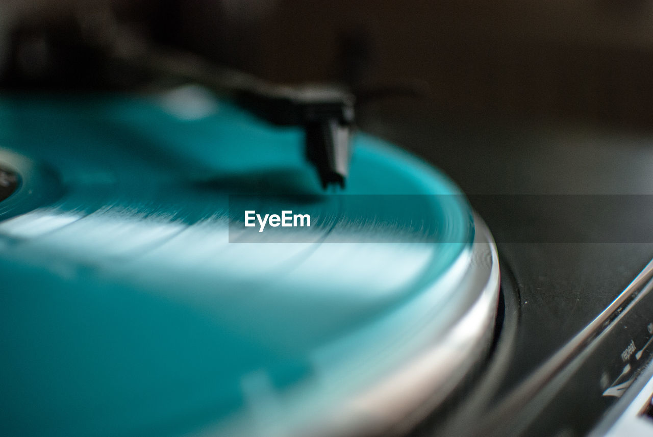 Close-up of turquoise record playing in turntable