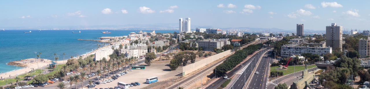 High angle view of cityscape by sea against sky