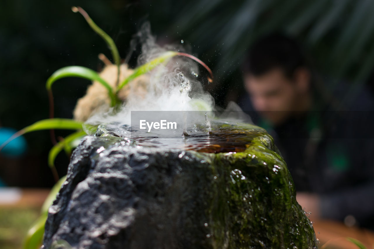 Close-up of smoke emitting from liquid in rock