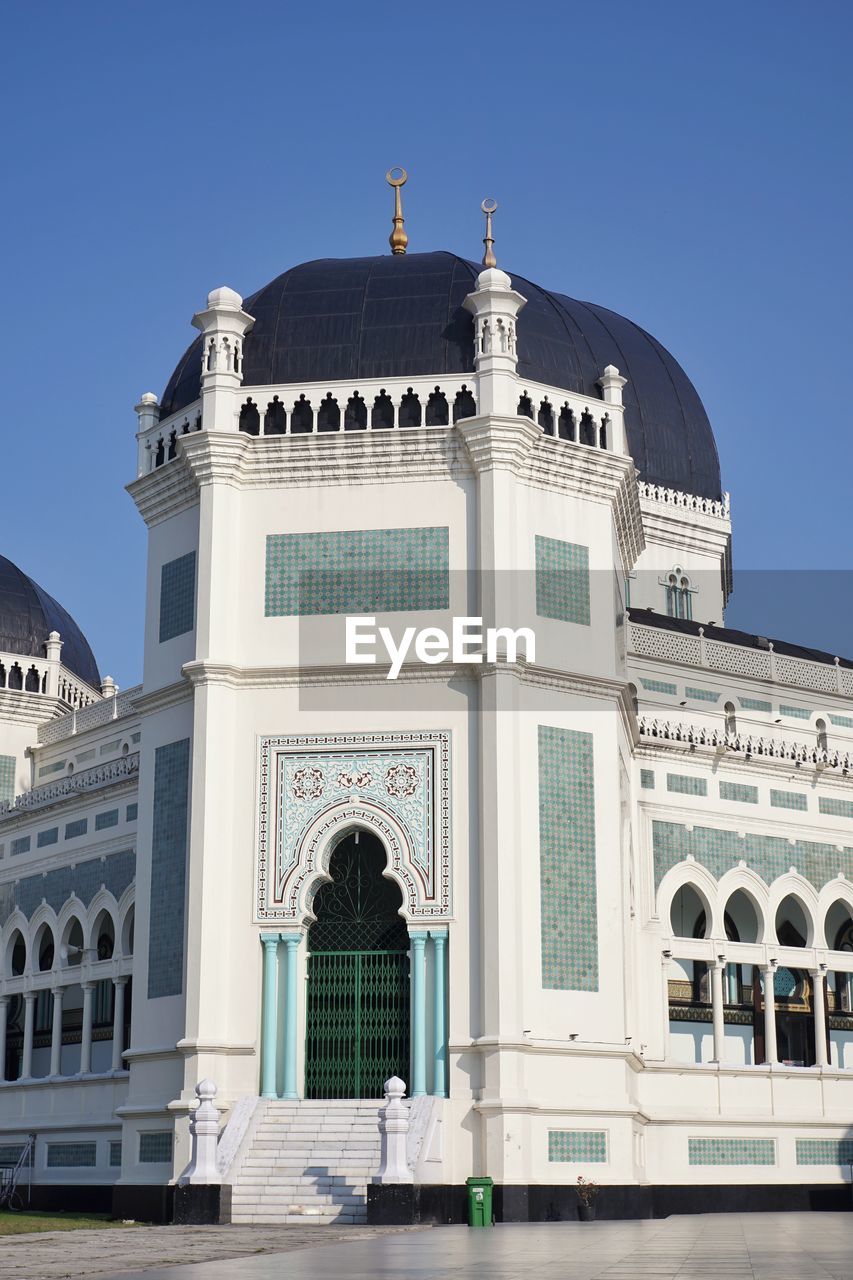 Low angle view of historical building ' masjid raya al mashun medan ' against blue sky
