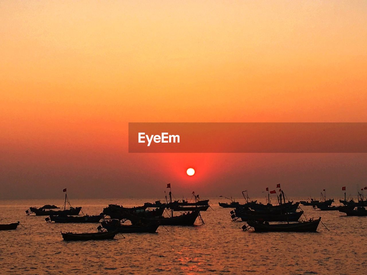 Boat sailing in sea at sunset