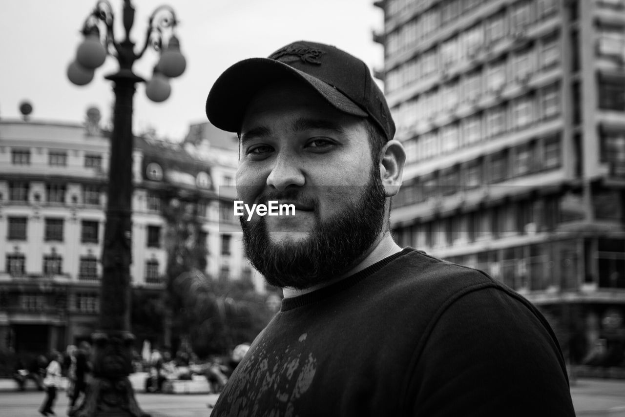 Portrait of man against buildings in city