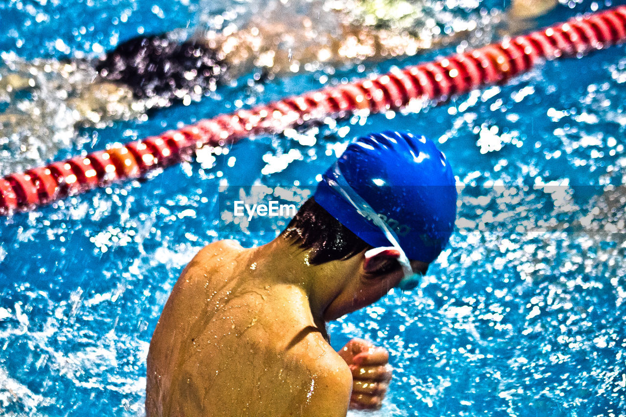 Rear view of swimmer swimming in pool