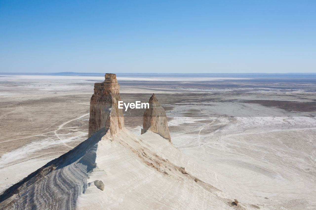 sky, land, scenics - nature, nature, natural environment, landscape, sand, environment, sea, beauty in nature, blue, water, clear sky, horizon, beach, winter, travel, tranquility, travel destinations, day, no people, tranquil scene, snow, coast, non-urban scene, terrain, outdoors, geology, shore, tourism, desert, ocean, rock, sunny, copy space, horizon over water, sunlight, remote, ice