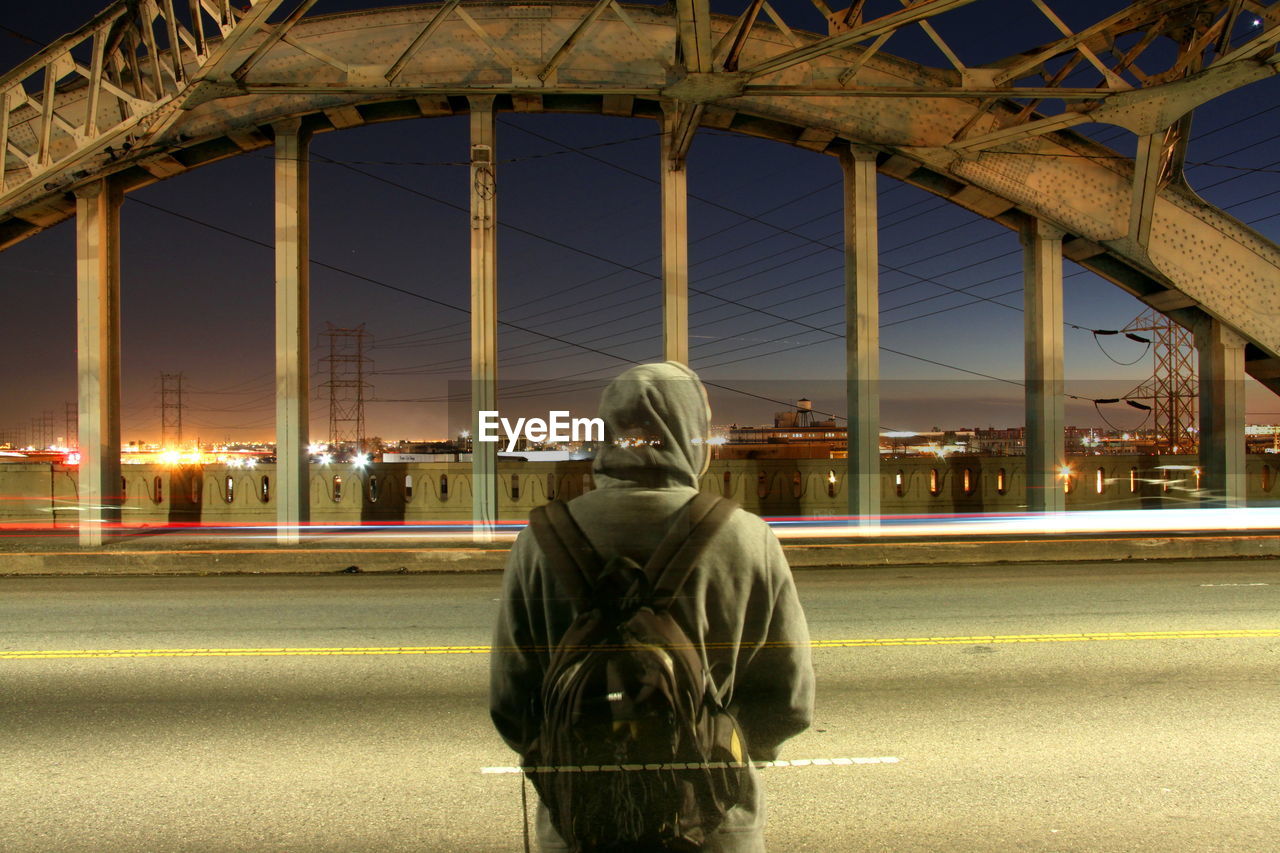 rear view of man walking on street at night