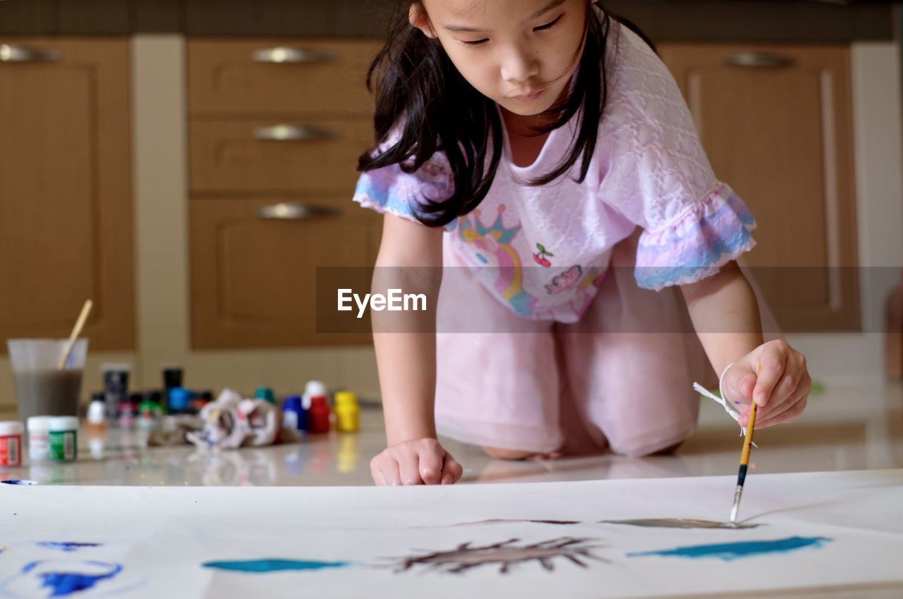 High angle view of girl painting on floor 