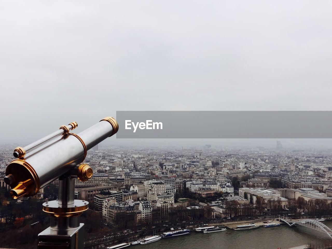 Hand-held telescope against cityscape