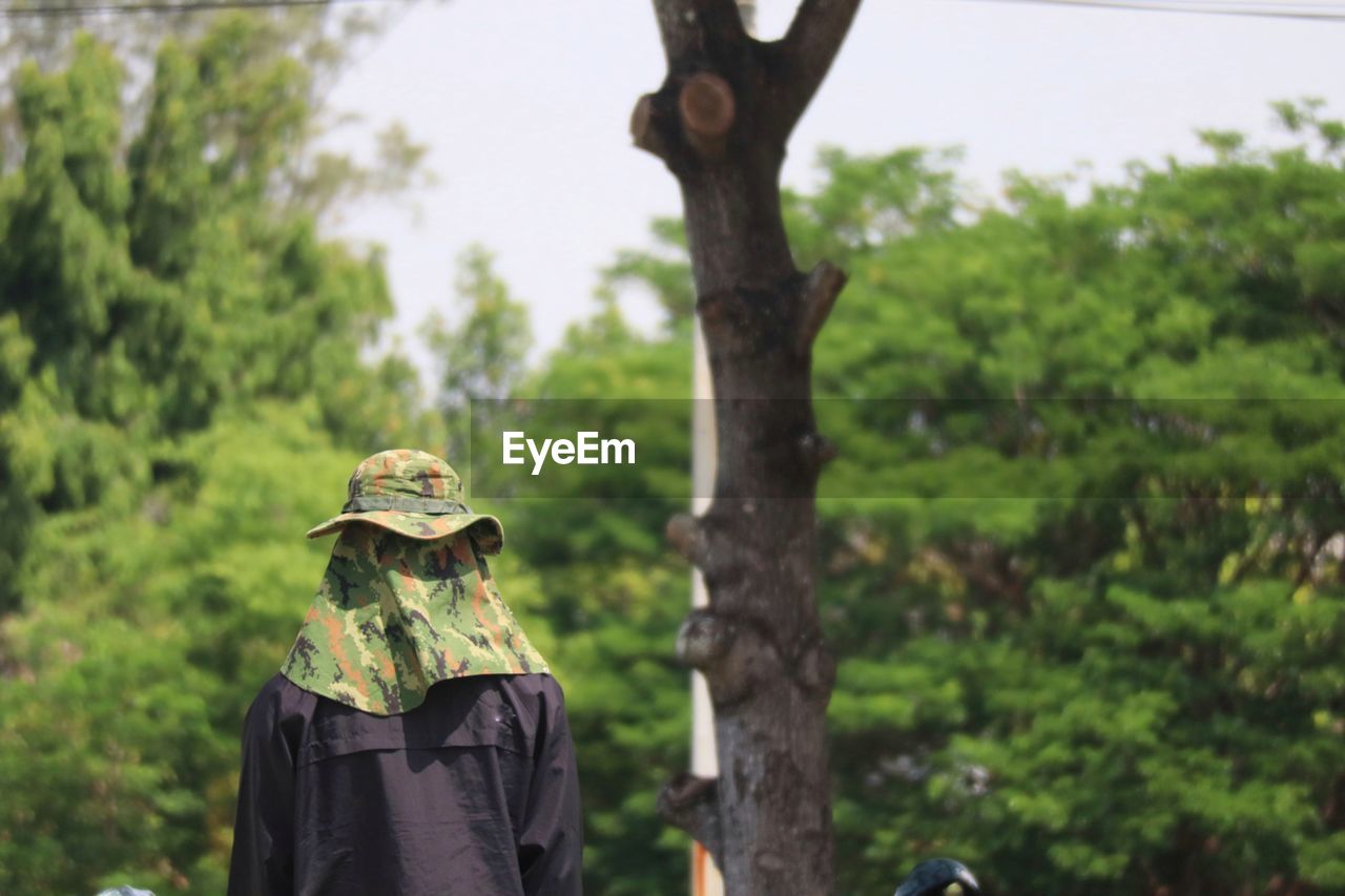 Rear view of man standing against trees