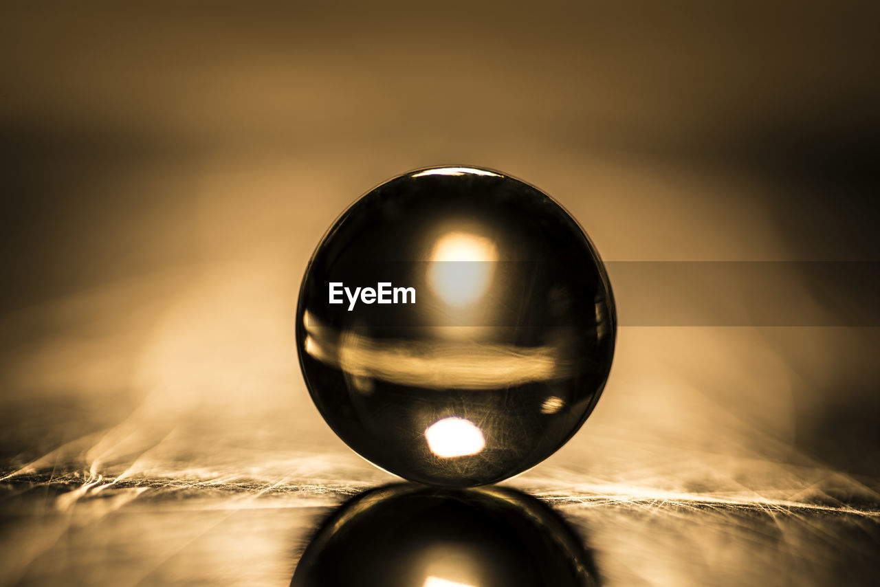 CLOSE-UP OF CRYSTAL BALL ON GLASS