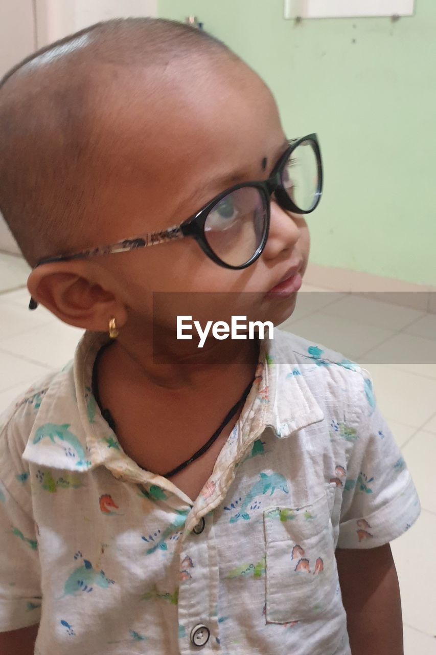 CLOSE-UP PORTRAIT OF A GIRL WEARING EYEGLASSES