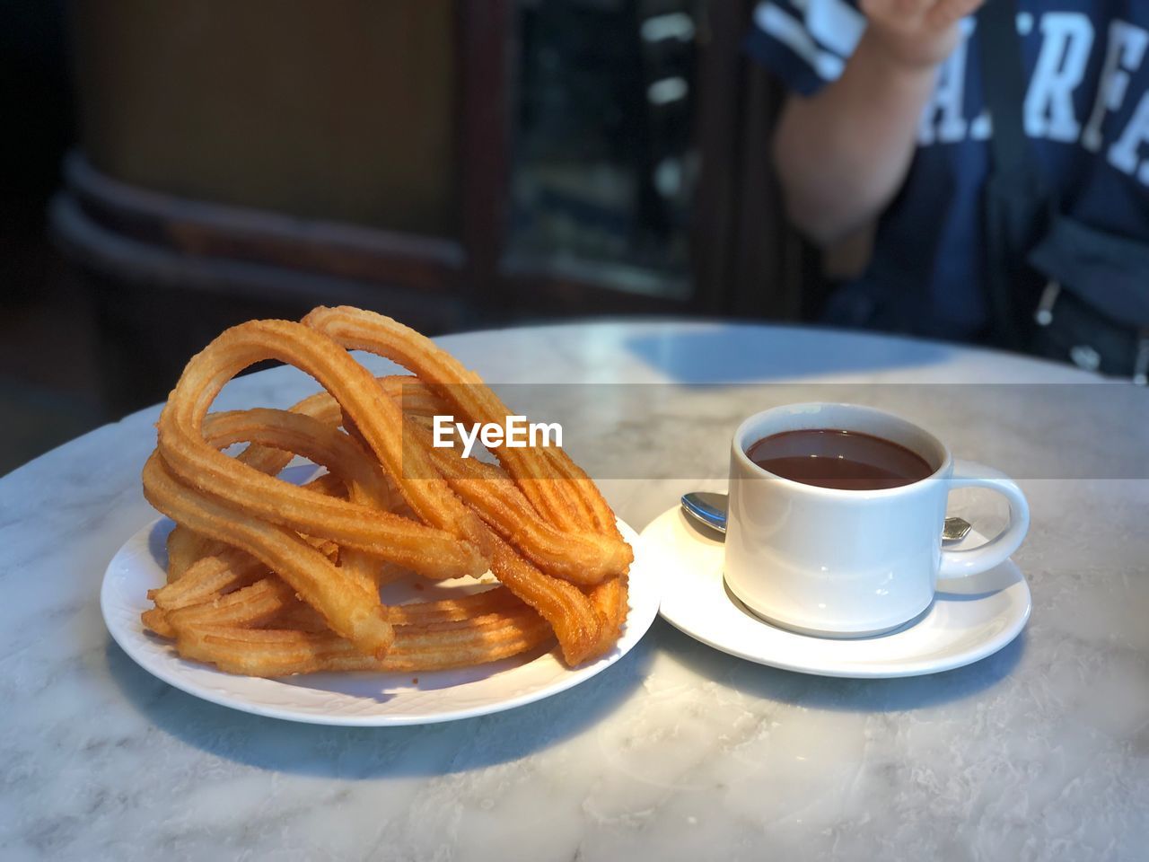Breakfast with person in background on table