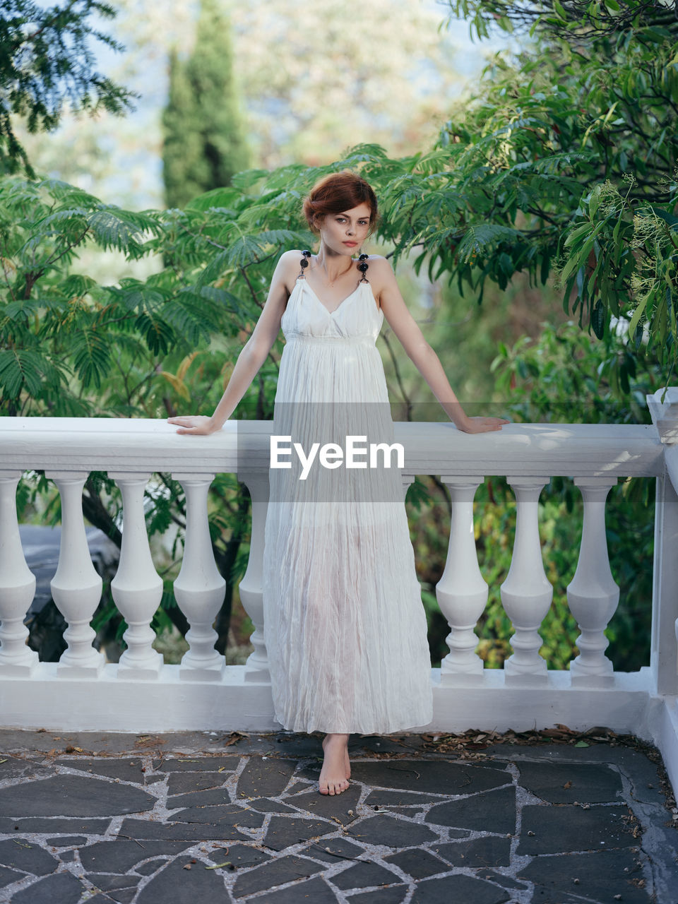 WOMAN STANDING ON WHITE RAILING