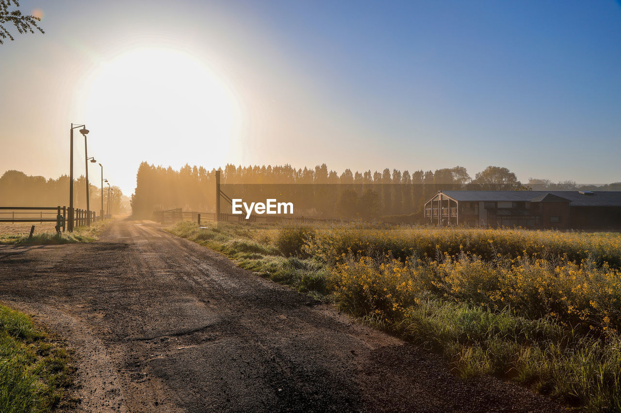 ROAD BY FIELD AGAINST SKY