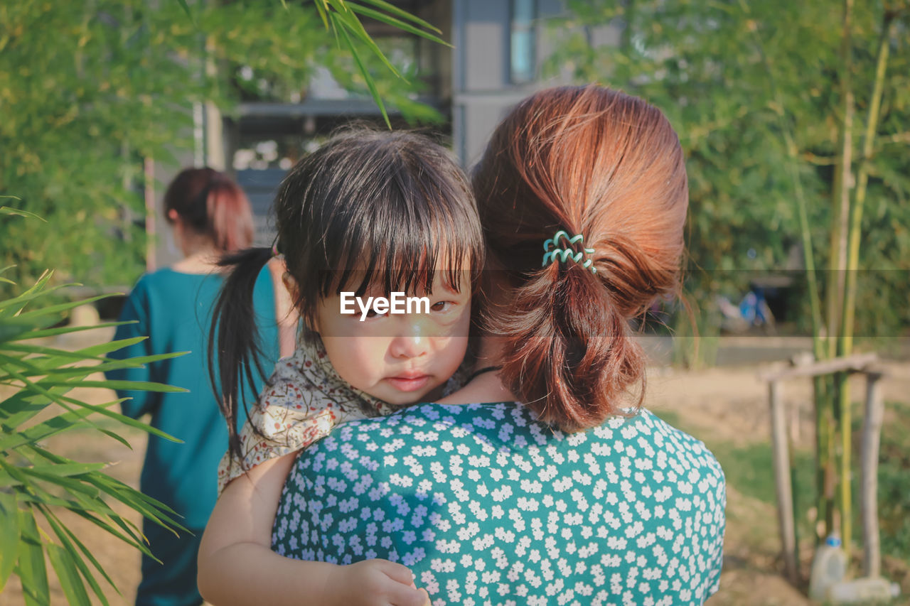 Rear view of woman and girl looking at camera