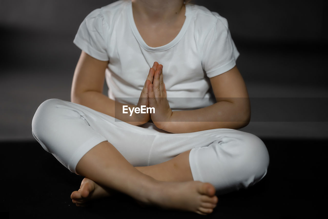 low section of woman sitting on bed