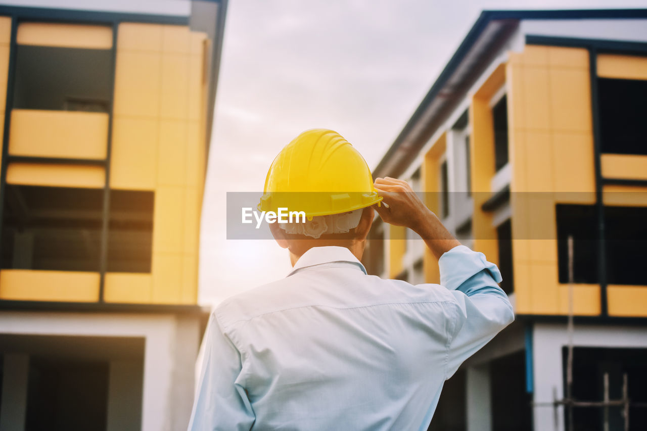 Foreman construction project control holding hard hat safety at estate