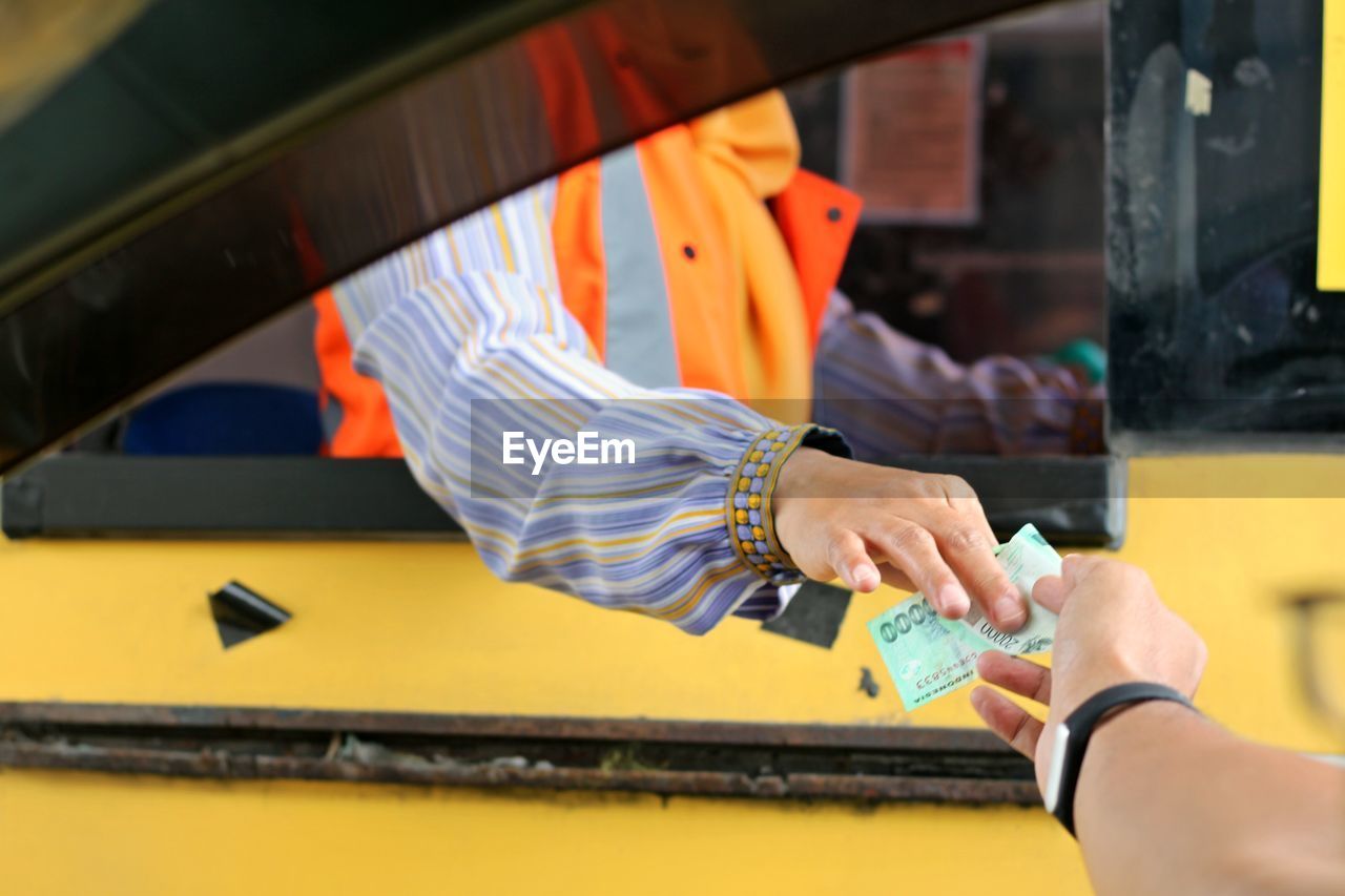 Cropped image of hand paying toll to man