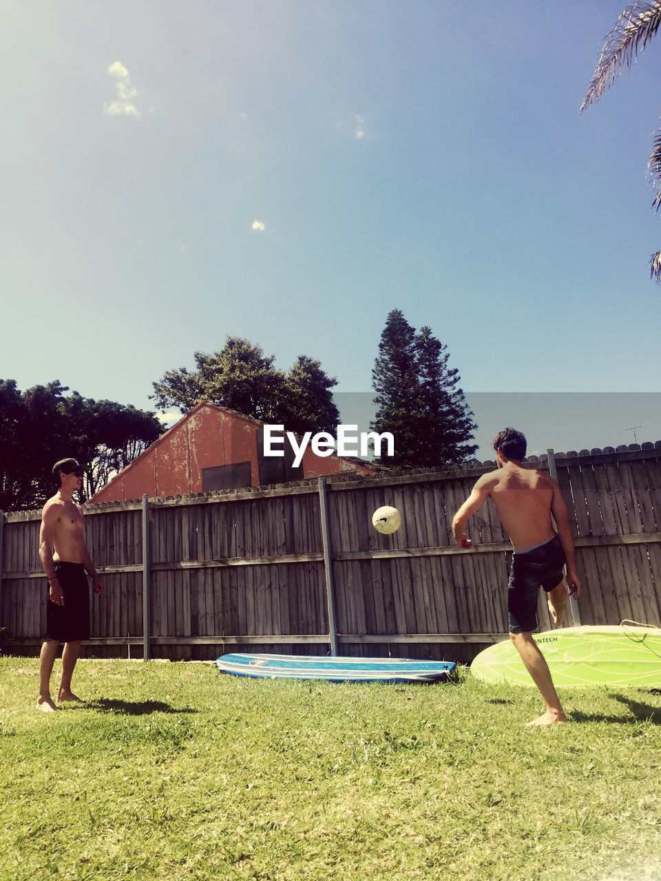 MAN STANDING IN YARD AGAINST SKY