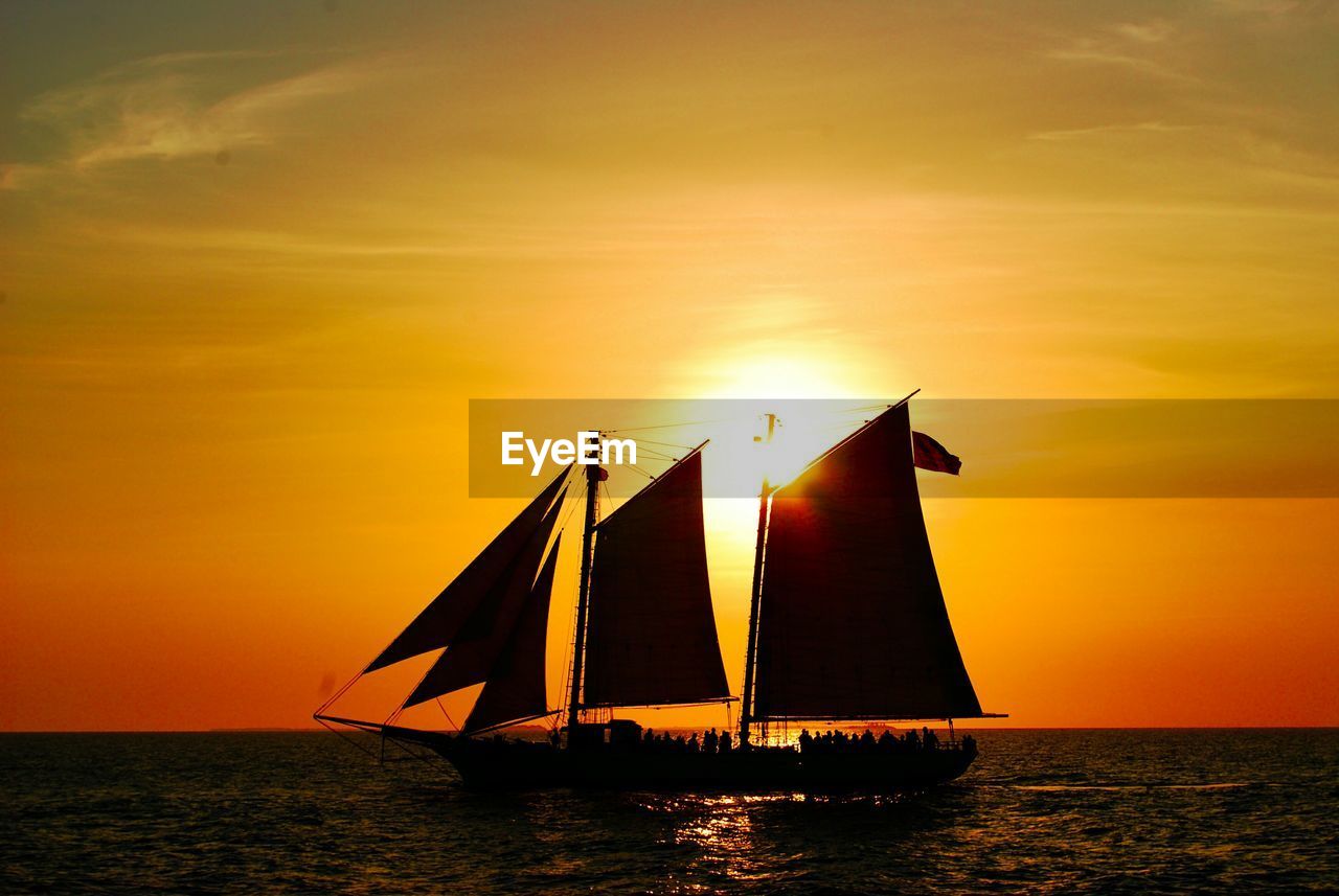 Silhouette sailboat on sea against sky during sunset