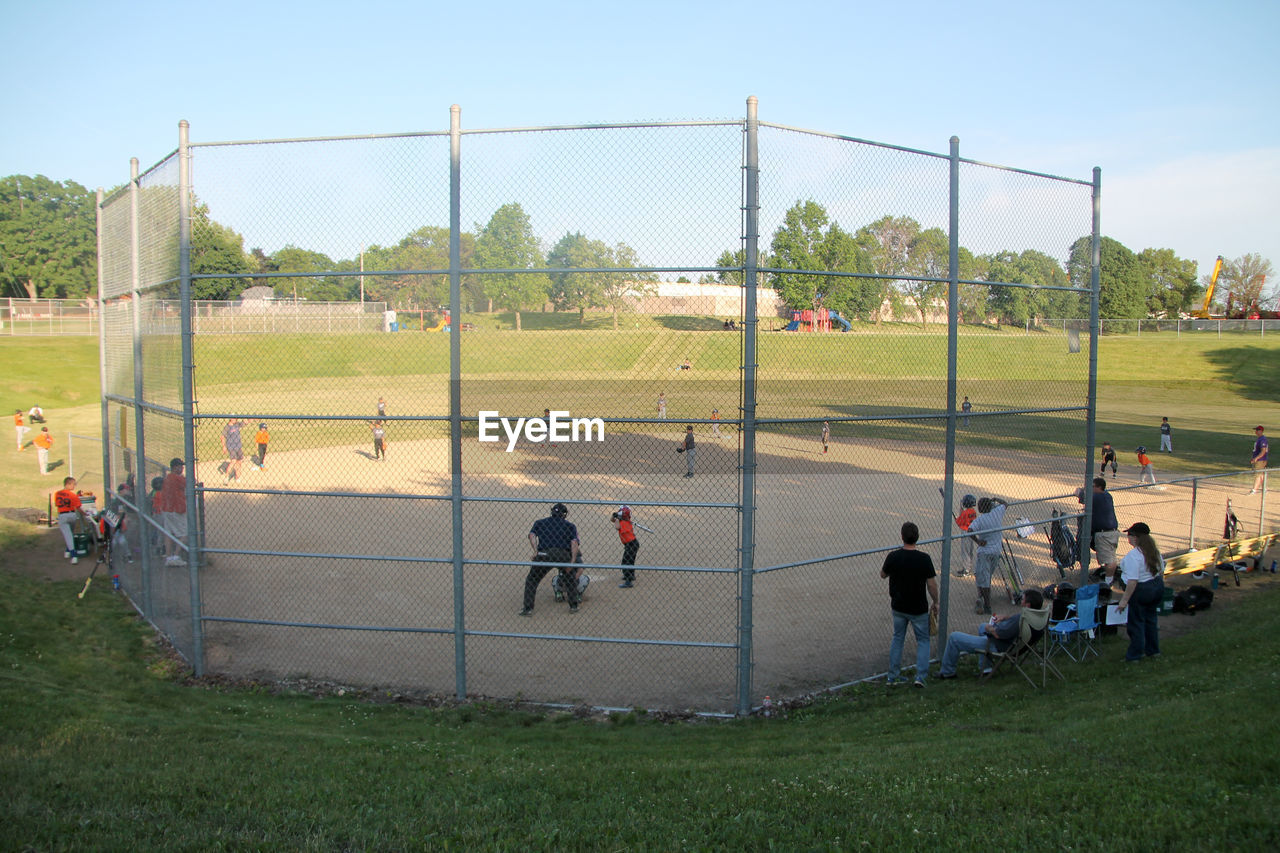 HIGH ANGLE VIEW OF PEOPLE RUNNING ON FIELD