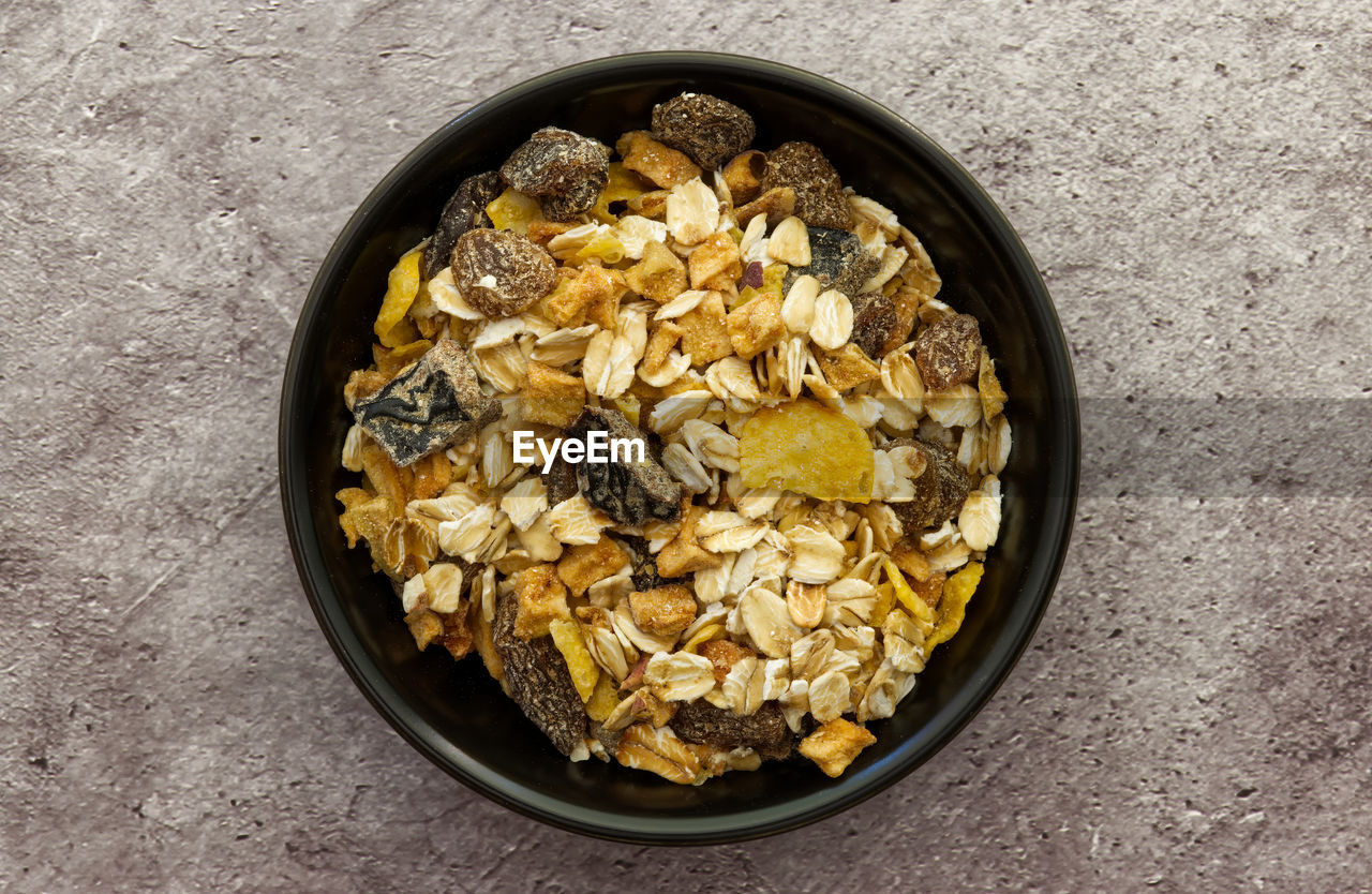 Bowl of muesli isolated on grey concrete background. top down view. healthy breakfast