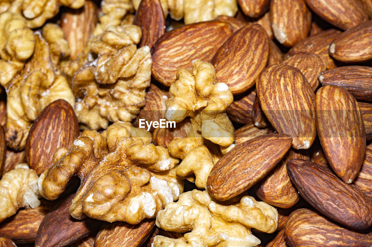 Peeled almond seeds and walnuts, close up background.