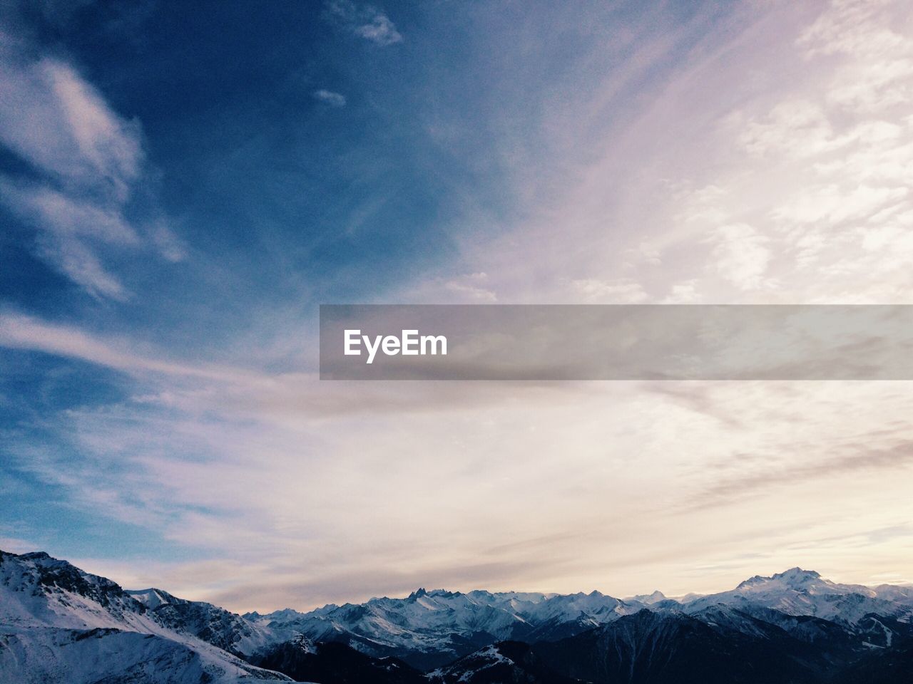 Scenic view of snowcapped mountains against sky during sunset