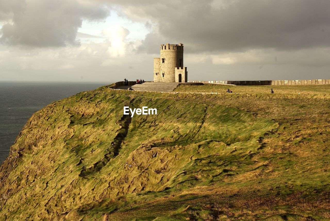 Castle on mountain by sea against sky