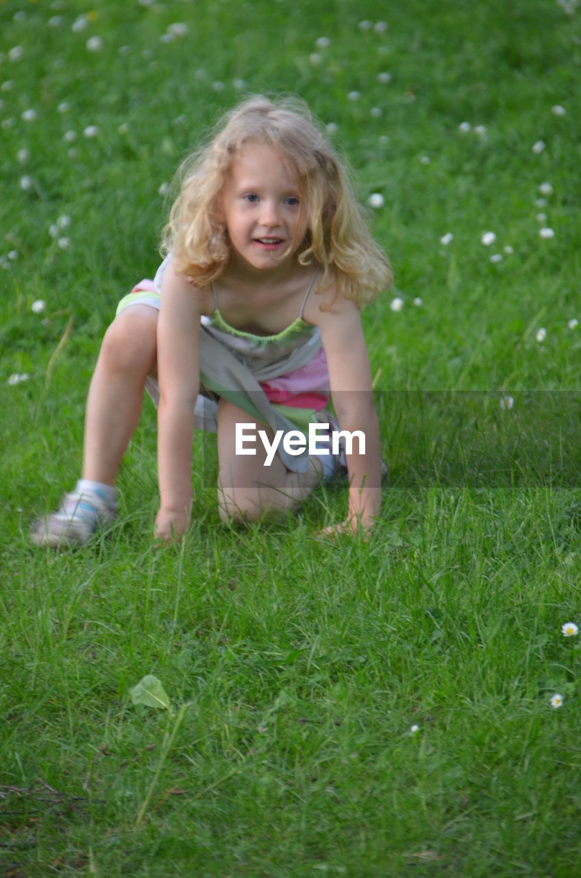 PORTRAIT OF SMILING GIRL IN GRASSY FIELD