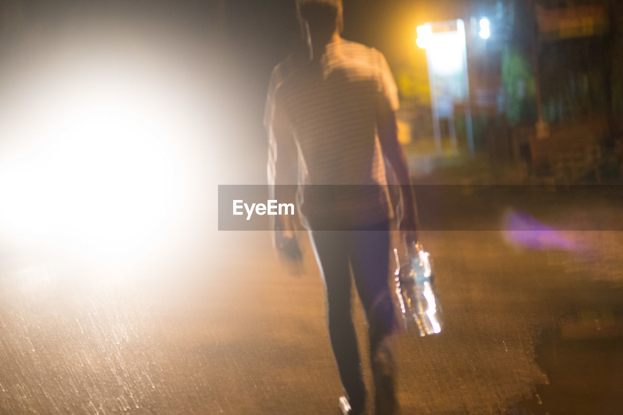 Blurred motion of man on street at night