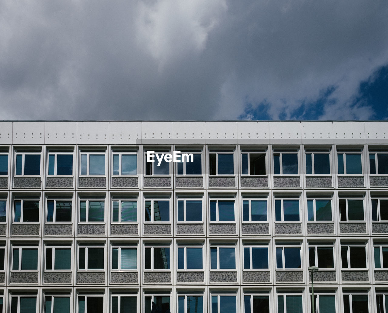 BUILDING FACADE AGAINST CLOUDY SKY