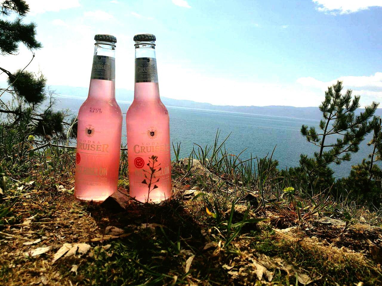 CLOSE-UP OF BOTTLE ON BEACH