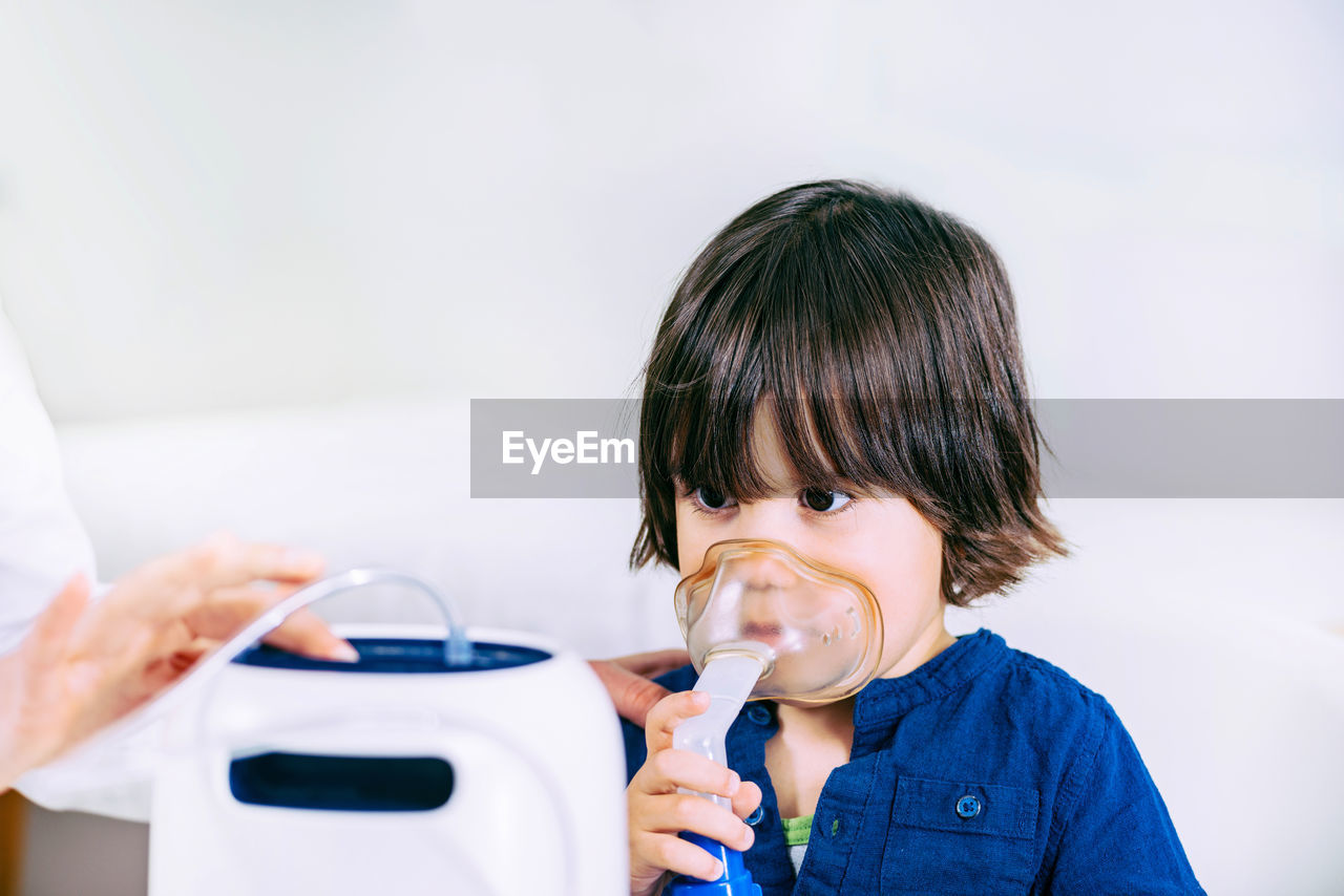 Cute girl wearing oxygen mask in hospital