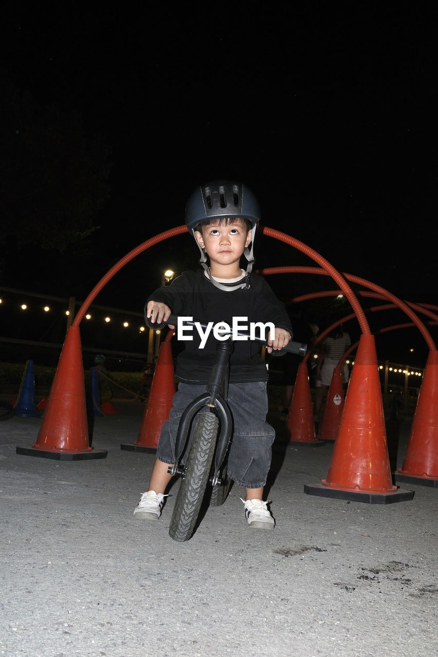 portrait of boy riding push scooter on street