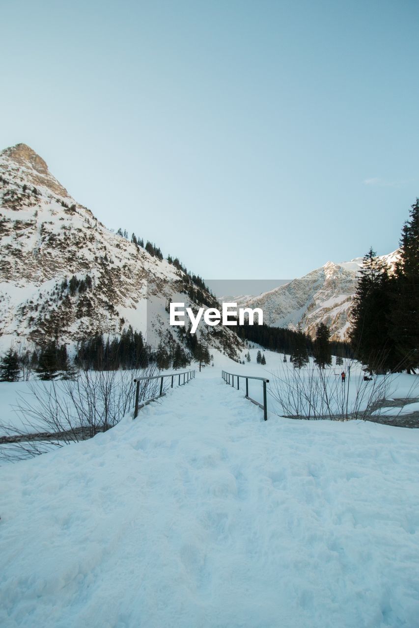 Scenic view of snow covered mountains against clear sky