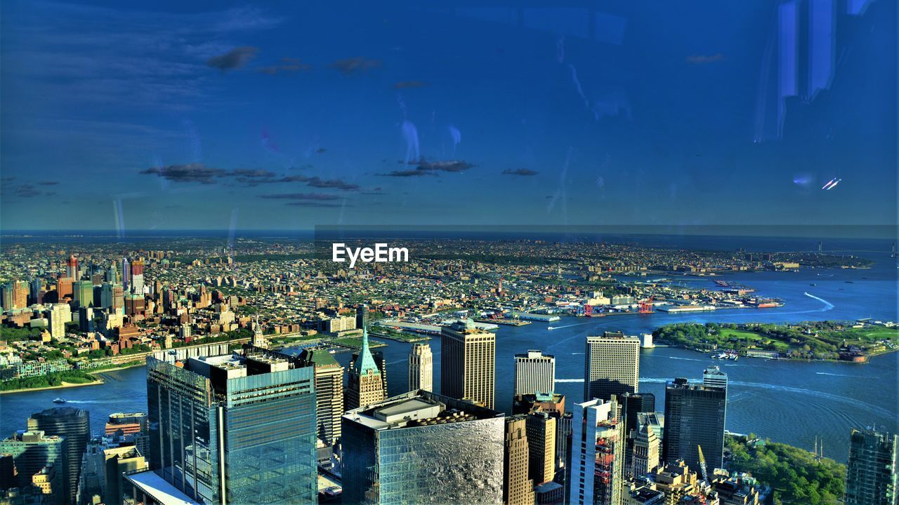 High angle view of city by sea against sky